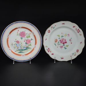 Lote constando de <b>dois pratos</b> circulares em porcelana Companhia das Índias Família Rosa. Um com borda em ondulações e o outro com borda em azul índigo. Ambos com decorações floridas predominando a tonalidade rosa. Séc. XVIII. Diâm. de ambos 23,5 cm