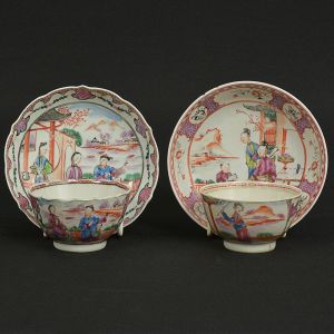 Lote constando de: a) <b>"Bowl" para chá com seu pires</b> em porcelana Companhia das Índias decorada em policromia Mandarim com diversos personagens em cenas de exterior com barcos, casario e montanhas. Séc. XVIII. Imperceptível fio no "bowl". Diâm. do pires 12,5 cm; Alt. do "bowl" 4,5 cm; b) <b>"Bowl" para chá com seu pires</b> em porcelana Companhia das Índias decorada em policromia Mandarim com personagens em cena de exterior. Séc. XVIII. "Bowl" com restauro na base. Alt. do "bowl" 3,5 cm; Diâm. do pires 13 cm