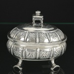 <b>Caixa</b> oblonga em prata inglesa decorada com gravados de arabescos. Pega da tampa modelada com banqueta encimada por coroa. Pés revirados. Contraste da cidade de Londres de 1904 e marca do prateiro C. S. HARRIS & SONS Ltd. Peso 380 gramas. Compr. 15,5 cm