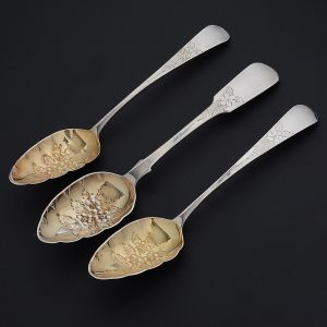 Lote constando de <b>3 colheres</b> "strawberry spoons" em prata inglesa. Um par do período George III com contraste de Londres de 1812 e uma avulsa do período William IV com contraste de Londres de 1836. Todas elas parcialmente em "vermeil" e lavrados floridos. Compr. 21,5 cm e 23 cm. Peso 180 gramas.