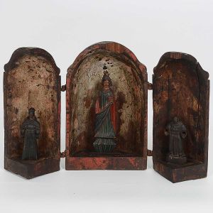 Raro <b>oratório bala</b> em madeira apresentando duas portas rebatíveis com três imagens no interior. Fundo e imagem central policromados. Uma das portas com rachadura longitudinal e faltam duas pequenas partes. Ferragens de época. Minas Gerais. Séc. XVII / XVIII. Alt. 33 cm