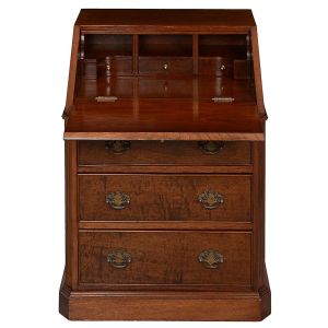 Pequena <b>escrivaninha</b> no estilo inglês construída em madeira nobre. Escritório com tampo reclinável, apresentando no interior escaninhos e gavetas. Parte inferior com três gavetas. Puxadores metálicos. Med. fechada 80 x 61 x 52 cm