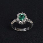 <b>Anel </b>em ouro branco 18k, com esmeralda oval estilo "Maracanã", com brilhantes. Peso 5,5 gramas.