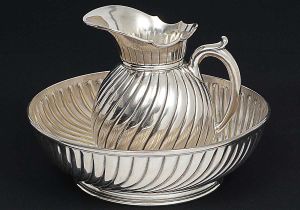 <b>MAISON CHRISTOFLE</b> - Antigo <b>jarro e sua bacia</b> em metal espessurado a prata, decorado com frisos levemente retorcidos. Marca da "orfèvrerie" em ambas as peças. Alt. do jarro 29 cm; Diâm. da bacia 42 cm