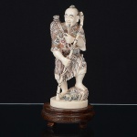 Antiga <b>figura masculina</b> chinesa em marfim entalhado com vestes policromadas. Base em madeira. Alt. 16 cm