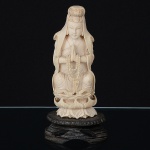 Antiga <b>estatueta</b> chinesa em marfim representando figura de divindade orando sobre flor de lótus. Alt. 13 cm