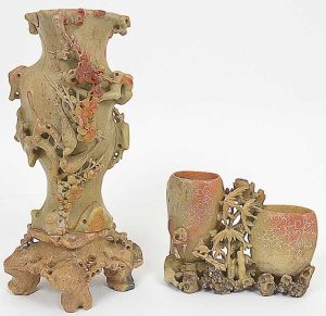 Antigo <b>conjunto de 2 vasos</b> japoneses em jade. O maior de forma alongada decorado com guirlandas, galhos e dois pássaros românticos. O menor com dois recipientes gravados com frutos e folhas vazadas. Este último com pequenos quebradinhos. Alt. 30 cm e 12,5 cm