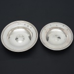 Conjunto de <b>2 cinzeiros </b>circulares em prata inglesa lisa com borda filetada. O maior com contraste de Sheffield de 1940 e o menor com contraste de Londres de 1977. Ambos com marcas de prateiro. Diâm. 12 cm e 10,5 cm. Peso 200 gramas.