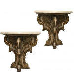 Antigo <b>par de pequenos consoles de parede</b> no estilo francês construídos em madeira patinada de bege e realçada a ouro, em belos entalhes fitomorfos. Tampos em mármore com bordas boleadas e onduladas. Med. 65 x 67 x 34 cm