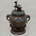 <b>Braseiro</b> chinês em "cloisonné", de feitio bojudo, decorado com arabescos policromados. Pegas do bojo modeladas em cabeças de elefantes. Triplos pés decorados com estilizações de cães de fó e pega da tampa modelada em cão alado. Séc. XVIII / XIX. Alt. 53 cm; Compr. 42 cm