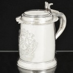 Raríssimo <b>"tankard"</b> de coleção em prata inglesa do início do período Queen Anne. Bojo cilíndrico com grande brasão lavrado ao centro, centralizado por volutas e alça em "S" invertido. Contraste da cidade de Londres de 1704 e marca do prateiro JOHN SUTTON. Séc. XVIII. Alt. 19,5 cm. Peso 890 gramas.