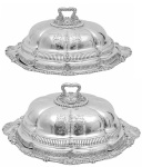 Majestoso conjunto de <b>2 "entrée dishes"</b> em prata inglesa do período George III. Apresentam grande brasão armorial e decoração "Regency" com abafadores em largos gomos, godrões, "coquilles" e folhas de acanto. Pegas dos pratos em estilizações concheadas e das tampas em cabeças de leão apoiadas em grandes rosáceas. Contraste da cidade de Londres de 1812 e 1813 e marca do prateiro da casa real PAUL STORR. Med. 23 x 48 x 34 cm e 28 x 63 x 46 cm
