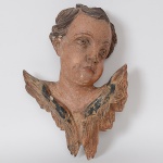 <b>Cabeça de anjo</b> barroco em madeira entalhada e policromada. Minas Gerais. Séc. XVIII. Alt. 40 cm