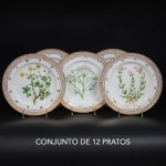 <B>Conjunto de 12 pratos de jantar </b>em porcelana dinamarquesa da importante manufatura Royal Copenhagen modelo "<B>Flora Danica</B>". Cada peça, inteiramente pintada à mão em belíssima policromia com suas designações botânicas e numeração no verso. Apresentam bordas em mínimos picotados cobertos a folha de ouro. Diâm. 25,5 cm
