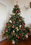 Imponente Árvore de Natal decorada com bolas, laços, pisca-pisca e diversos enfeites Natalinos em di