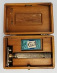 Gillette - Aparelho de barbear em metal. Acondicionado em estojo de madeira. Medindo; 3 x 4 x 10 cm. O King Camp Gillette foi um inovador americano e introduziu o aparelho de barbear no mercado em 28 de setembro de 1901. Gillette foi iniciado na "Adelphi Lodge", em Quincy, Massachusetts, em junho de 1901.