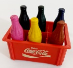 Engradado miniatura Coca Coca garrafas de plasticos coloridas.