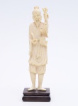Estatueta em em marfim oriental representando figura de ancião. Altura: 17 cm.