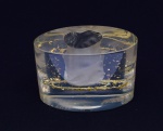 Peça oval em acrílico, assinada MAY. Vasada na parte superior, interior do acrílico realçado  com fagulhas douradas. Medidas: 13 cm x 7 cm. Altura: 9 cm.