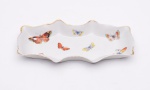 Petisqueira em porcelana francesa, Limoges, decorada com figuras de borboleta, sendo uma borboleta meio apagada. Medidas: 23 cm x 12 cm. Altura: 3 cm.