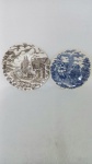Dois pratos decorativos, sendo um em porcelana inglesa e outro em porcelana nacional. Diâmetro: 22 cm e 19 cm.