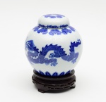 Polovi, potiche em porcelana branca decorado com figuras orientais no tom azul. Acompanha base de madeira. Altura: 20 cm.