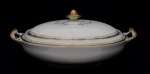 Sopeira redonda em porcelana inglesa ALFRED MEAKIN na cor predominante bege com detalhes em ouro. Apresenta pequeno "fio de cabelo" na lateral. Diâmetro: 23 cm. Altura: 10 cm.