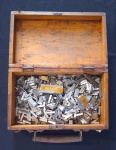 Centenas  de Fontes de Tipografia acondicionadas em pequena Caixa de madeira com alça em metal. 25x1