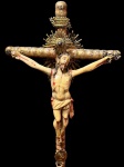 PRECIOSO CRUCIFIXO DE ALCOVA EM MADEIRA E MARFIM COM GUARNIÇOES EM PRATA REVESTIDA EM OURO E RESPLENDOR REMATADO POR DIAMANTE. DE VERTENTE INDO PORTUGUESA ESSA É UMA JÓIA DO PERÍODO JOANINO NO INICIO DOS ANOS 1700. A CRUZ EM MADEIRA FORRADA EM OURO É ESCULPIDA EM ELEGANTES TORNEADOS HINDÚS. A BASE FACETADA TEM ARREMATES CARACTERÍSTICOS. O CRISTO VIVO DE PIDEDOSO SEMBLANTE APRESENTA POLICROMIA DELICADA. A LINDA GUARNIÇÃO EM PRATA REVESTIDA EM OURO COMPOE-SE DE TITULO CRUCIS (PLACA INRI) CIRCUNDADA POR PEROLADO REMATADO POR FLORES. RESPLEDOR COM CRAVAÇÃO DE DIAMANTE, RAIOS COM NUVENS QUE ADORNAM O CIRSTO E UMA PLACA SOB OS PÉS DECORADO COM LAURÉU QUE EMOLDURA CORAÇÃO TRESPASSADO. UM EXEMPLAR MAGNIFICO, BELISSIMO E REQUINTADO! GOA, INICIO DO SEC. XVIII. 31 CM DE ALTURA. NOTA: No decurso dos séculos  XVII e XVIII, Portugal e Espanha foram os mais profícuos produtores de arte sacra em marfim no mundo. Isso graças as colônias ultra marinas estabelecidas pelos dois países em África e no Oriente. Nestes locais encontraram o  OURO BRANCO como era chamado o marfim. A nobreza do materal se propagou junto aos Reis, Nobres e a Igreja  graças ao exotismo de sua origem (As míticas terras longínquas e os lendários elefantes aludidos pelos historiadores antigos em suas crônicas de riqueza e poder dos elefantes  como irresistíveis máquinas de guerra). A alva, pura e etérea beleza do material cedo  levou-o a ser adotado pela igreja na representação das sagradas imagens religiosas.   De fato, o descobrimento do caminho marítimo para a Índia em 1448, é considerado um fato hercúleo dos Descobrimentos e um grande empreendimento histórico, no qual tudo o que se descobriu resultou na descoberta das rotas marítimas para o Oriente. No Índico estabeleceram-se contatos com as cidades de Sofala, Quíloa, Mombaça e Melinde logo nas duas primeiras viagens, em 1498 e 1500. Cidades que, fazendo parte do império muçulmano, enriquecido pelo comércio do ouro, abrangia a zona costeira desde Sofala até Melinde. Desde logo, estabelecidos contatos comerciais, criadas feitorias e, pouco depois, conquistadas, de que resultaram, mais tarde, fortes influências culturais e consequências artísticas. Na Índia, depois de já estabelecidos em Cochim, optou-se pelo domínio efetivo dos mares; pela instalação de feitorias junto a cidades importantes e, para executar o plano de Afonso de Albuquerque, 2º Governador da Índia (1509-1515) que conquistou Goa, Malaca e Ormuz, três pontos estratégicos para o domínio dos mares e, por essa via, de todo o comércio. A transferência da capital, de Cochim para Goa, a conquista de várias cidades, como Calecut, a construção de feitorias, como em Diu, contribuíram para a existência de dispersas possessões na costa ocidental indiana, com a consequente influência cultural e produção artística, diferenciada mediante o local de produção e respetivas influências. Mais tarde, no Ceilão foi construída a primeira fortaleza em Columbo em 1518, iniciando o império português na ilha, que durou até princípios do século XVII, perdido para os Holandeses no final mesmo século. Dessa prolongada permanência no Ceilão resultaram, fortes laços culturais e rica produção artística. Com o objetivo de atingir os centros produtores de duas especiarias muito estimadas, o cravo e a noz moscada, Afonso de Albuquerque, após ter conquistado Malaca, enviou dali, em 1511, ao descobrimento dos arquipélagos indonésios de Banda e Molucas uma pequena frota ... Desta mesma época data o descobrimento de Timor .... (Damião Peres, A História dos Descobrimentos Portugueses, pp. 141-142). A conquista de Malaca, assegurou o controle do estreito, passagem obrigatória do Índico para o Mar da China, importante conjunto de rotas comerciais que ligavam esta cidade com a costa Oriental da Índia  onde se controlou cidades como Negapatão, São Tomé de Meliapor, Paleacate e Masulipatão -, com o Golfo de Bengala  com destaque para a cidade de Hughli - e com o Sueste asiático  Birmânia, Sião e Camboja -, regiões essencialmente dominadas por aventureiros e comerciantes portugueses.  Melinde (Quénia) era aquela época um dos mais importantes entrepostos do tráfico, realizado pelos Árabes entre a costa oriental africana e os portos do Mar Vermelho, Arábia, Golfo Pérsico, Golfo de Cambraia e Costa do Malabar. No séc. XVI, aliada já aos portugueses, contava com 200 mil habitantes e o seu porto era o mais frequentado da África Oriental. A ligação à Guiné, ao Gana, ao Benim, ao Congo e a Angola; a Moçambique e às cidades da costa oriental africana como Sofala, Quíloa, Mombaça e Melinde; ao Mar Vermelho e ao Golfo Pérsico; a toda a costa ocidental indiana (na qual se inclui a Costa do Malabar); ao Império Mogol (no interior Norte do subcontinente Indiano); ao Ceilão; à costa oriental indiana; ao Golfo de Bengala e à Birmânia; à Malásia; ao reino do Sião; a Timor; à China; e ao Japão. Nestes lugares a que se denomina Estado da Índia (conjunto de territórios, estabelecimentos, bens, pessoas e interesses administrados, geridos ou tutelados pela coroa portuguesa, no Oceano Índico e mares adjacentes ou nos territórios ribeirinhos, do Cabo da Boa Esperança ao Japão), desenvolveram-se relações políticas, religiosas, económicas, comerciais, culturais que originaram manifestações artísticas como o mobiliário indo-português e a rica arte sacra que inspirou. Atribuiu-se a Goa, o principal centro de produção, mas também se admite a execução em toda a costa Malabar. (Couto, 1938: 3) O mobiliário e arte sacra indo-português foi executado nas regiões costeiras do Gujarate, do Concão e do Malabar, em que existiam fortificações portuguesas, para além, das terras do Grão-Mogol (Guzarate até aos Himalaias) e no norte da Índia, em que não existiu administração portuguesa ou domínio militar.