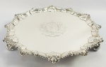 PRATA DE LEI GEORGIANA  MAGNIFICA SALVA EM PRATA DE LEI COM MARCAS PARA CIDADE DE LONDRES, LETRA DATA 1764. REINADO GEORGE III (1738-1820). MARCAS DOS PRATEIROS THOMAS HANNAN E RICHARD MILLS. DE FEITIO ELEGANTE A BORDA NO ESTILO ROCOCÓ É DECORADA COM REMATADOS E GODRONS. O PLANO TEM ESCUDO BIPARTIDO COM TRES FLORES DE LIZ, TRES CABEÇAS DE CERVOS E BANDAS. O ESCUDO É ARDONADO POR LUXUOSO SUPORTE VEGETALISTA COM RAMAGENS E FLORES. ABAIXO DO ESCUDO O LEMA  INDUSTRY REWARDED  INDÚSTRIA  RECOMPENSADA. A SALVA ROBUSTA E ESPESSA É APOIADA SOBRE TRÊS ELEGANTES PÉS. UMA SALVA MAGNIFICA, DE EXCEPCIONAL QUALIDADE E OBRA DE UM ARTÍFICE RECONHECIDO NO SEC. XVIII PELA EXCELENCIA DE SUA PRODUÇÃO. DE FATO, OS TRABALHOS DE THOMAS HANNAN SÃO REFERENCIADOS PELA ELEGÂNCIA E VIRTUOSE NA PRODUÇÃO. INGLATERRA, 1764. 30 CM DE DIAMETRO.  930 G