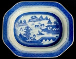 CIA DAS INDIAS CANTÃO BELA TRAVESSA OVAL EM PORCELANA UNDERGLAZE DO PERÍODO QIANLONG (1736-1795). BORDA COM BARRADOS EM AZUL. RESERVA COM CENAS LACUSTRES, COM BARCOS, PONTES E PAGODES. CHINA, SEC. XVIII. 35 CM DE COMPRIMENTO. NOTA: NOTA: Jean Hugues van Linschooten voltou para a Holanda, seu país natal, em 1593. Ele chegava de Goa, então a capital das colônias portuguesas do Oriente, onde ocupara a função de secretário do arcebispado. O retorno desse modesto funcionário a Amsterdã poderia ter passado despercebido a seus contemporâneos caso o viajante, ainda maravilhado por tudo o que vira, não tivesse redigido uma obra intitulada Itinerário, viagem ou navegação às Índias Orientais. Era uma verdadeira mina de informações sobre as fabulosas riquezas desses lugares longínquos, acrescida de uma lista de plantas e animais extraordinários que lá existiam e complementada por mapas, desenhos e anotações, de maneira a permitir uma navegação bastante segura a quem se aventurasse pela rota. O autor incitava seus compatriotas a organizar expedições para o Leste, sem esquecer Java, "uma ilha ainda não frequentada pelos portugueses, onde abundam diamantes, incenso e especiarias". Nessa época, Portugal e Espanha captavam em seus portos de Lisboa e Cádiz a maior parte das riquezas vindas do Oriente. Franceses, ingleses e holandeses se deslocavam até essas bases de comércio para adquirir as mercadorias que depois distribuíam em seus respectivos países. Um Capítulo especial de Linschooten se refere a profusão das porcelanas e a qualidade com que se apresentavam. Estas porcelanas nos séculos seguintes viriam a cair em cheio no gosto de nobres e burgueses europeus. Mas a que custo! A missão de um navio da Companhia das Índias durava muitos meses. Às vezes a embarcação só voltava ao porto de origem dois anos depois da partida, pois, além de as negociações comerciais no Oriente serem muito demoradas, era preciso esperar por ventos favoráveis para tomar o caminho de volta. Desde os portos do noroeste da Europa até Cantão, situado na costa chinesa, na embocadura do rio das Pérolas, um grande centro comercial, contam-se de 15 a 16 mil milhas. A partida da Europa dependia da data das monções. Levava-se quatro meses para atingir o cabo da Boa Esperança e, para passar por esse temível promontório na época propícia, era necessário sair da Europa no inverno, entre dezembro e março. A chegada a Cantão, ou mais exatamente a Wampu ou Huang Fu, acontecia, na melhor das hipóteses, no final do verão ou no início do outono, geralmente em setembro. A monção continental que se inicia em outubro levava os navios na direção do cabo. Além das circunstâncias imprevisíveis que sempre acompanham as expedições no mar, esses navios mercantes não dispunham de cartas marítimas elementares. Os portugueses guardavam em segredo as anotações feitas por seus capitães. Chegariam ao ponto de falsificar algumas delas, assim como fariam os holandeses mais tarde, deixando-as "escapulir" para as nações concorrentes, na intenção de provocar desastres ou naufrágios, dos quais tiravam, evidentemente, total benefício. Portugal estabeleceu com Cantão um monopólio de comércio que se revelou por mais de um século como uma lucrativa empreita. Por isso era frequente o uso de porcelana característica do Cantão nos países membros do império ultramarino português