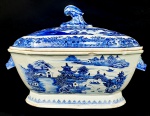 CIA DAS INDIAS CANTÃO GRANDE E MAGNIFICA SOPEIRA  EM PORCELANA UNDERGLAZE DO PERÍODO QIANLONG (1736-1795). BORDA COM BARRADOS EM AZUL. RESERVA COM CENAS LACUSTRES, COM BARCOS, PONTES E PAGODES. ALÇAS LATERAIS COM FEITIO DE CABEÇAS DE LEBRES. CHINA, SEC. XVIII. 35 CM DE COMPRIMENTO. (TAMPA DO MESMO PADRÃO MAS LIGEIRAMENTE MENOR DEVENDO TER SIDO TROCADA EM ALGUM MOMENTO ANTERIOR)