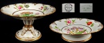 CREIL PERÍODO CASAUX MEDAILLE DOR 1834. RARO E MAGNIFICO PAR DE FRUTEIRAS E STAND CAKE  EM OPAQUE DE PORCELAIN COM MARCAS DA MANUFATURA CREIUX DEC. 1830. ESTILO CARLOS X. EXUBERANTE DECORAÇÃO COM ESMALTES MANUAIS APRESENTANDO FLORES E RELEVOS REALÇADOS EM OURO. ESTE MODELO FOI CRIADO PELA CREIL MANUFACTORY NA ÉPOCA CHAMADA ST CRICQ-CASAUX & CIE ANTES DE SE FUNDIR COM A MONTEREAU, EM 1840. FRANÇA, 22 CM DE DIAMETRO