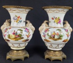 KPM BERLIM  - PAR RICOS VASOS EM PORCELANA COM GUARNIÇÃO EM BRONZE. DECORADOS COM CENAS GALANTES E ESMALTES FLORAIS. PEGAS LATERAIS COM FEITIO DE CABEÇAS DE CARNEIROS. ARREMATES EM OURO. ALEMANHA, FINAL DO SEC. XIX. 21 CM DE ALTURA