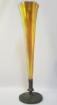 TIFFANY FAVRILE GLASS TRUMPET VASE (EX COLEÇÃO LUCIANO TADINI). GRANDE FLOREIRO EM VIDRO FAVRILE COM GUARNIÇÃO EM BRONZE DA MANUFATURA TIFFANY COM FEITIO DE TROMPA. ICONICO MODELO ASSINADO LOUIS CONFORT TIFFANY FAVRILE. FORMA PAR COM O APREGOADO NO LOTE A SEGUIR. EUA, INICIO DO SEC. XX. 49 CM DE ALTURANOTA: inovador vidro Favrile da Iridescência Tiffany foi feito adicionando óxidos metálicos ao vidro fundido para que ele realmente se tornasse parte do vidro e criasse uma iridescência suave, profunda, luxuriante e brilhante com uma gama de cores. A maioria das outras empresas criou efeitos iridescentes pulverizando óxidos como o óxido estanoso na superfície da peça.