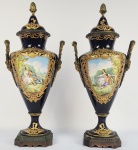 SEVRES - EXPLENDIDO PAR DE ANFORAS EM PORCLEANA COM FUNDO NA TONALIDADE AZUL COBALTO E  GURANIÇÃO EM BRONZE ORMOLU. DECORADAS COM REQUINTADAS RICAILES EM OURO RELEVADO E RESERVAS COM CENAS DE ROMANCE IDÍLICO EM UMA DAS FACES E CENA LACUSTRE NA FACE OPOSTA. ALÇAS LATERAIS REMATADAS POR MGNIFICAS CARIATIDES. FRANÇA, SEC. XIX. 45 CM DE ALTURA