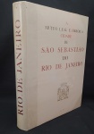 A MUITO HEROICA CIDADE DE SÃO SEBASTIÃO DO RIO DE JANEIRO - PARIS  MARCEL MOUILLOT, 1965, 1ª EDIÇÃO ORIGINAL. TEXTOS E SELEÇÃO DE DOCUMENTOS POR GILBERTO FERREZ. TIRAGEM DE 1.000 EXEMPLARES, NUMERADOS DE 1 A 1.000 E 100 EXEMPLARES, FORA DO COMÉRCIO, NUMERADOS EM ALGARISMOS ROMANOS, RESERVADOS À COMISSÃO ORGANIZADORA E AOS COLABORADORES, SENDO QUE AS MATRIZES QUE SERVIRAM PARA A ILUSTRAÇÃO FORAM DESTRUÍDAS. ESTE É O EXEMPLAR Nº 323. QUATRO SÉCULOS DE EXPANSÃO E EVOLUÇÃO. INICIATIVA DE RAYMUNDO DE CASTRO MAYA EM COMEMORAÇÃO DO IVº CENTENÁRIO DA FUNDAÇÃO DA CIDADE. TEXTOS E ORGANIZAÇÃO DE GILBERTO FERREZ. EXECUTADO EM PARIS SOB A DIREÇÃO DE MARCEL MOUILLOT. EDITADO POR RAYMUNDO DE CASTRO MAYA, CANDIDO GUINLE DE PAULA MACHADO, FERNANDO MACHADO PORTELLA, BANCO BOAVISTA SA 1965. ENCADERNAÇÃO DO EDITOR EM PERCALINA COM GRAVAÇÃO A OURO NA CAPA ANTERIOR. ILUSTRADO COM UMA VASTA E INTERESSANTE SELEÇÃO DE AGUARELAS, GRAVURAS, MAPAS, DOCUMENTOS E FOTOS, TANTO A CORES, COMO A PRETO E BRANCO. IMPRESSO SOBRE PAPEL MUITO INCORPADO E DE QUALIDADE PURO LINHO FILIGRANADO COM AS ARMAS DA CIDADE DO RIO DE JANEIRO. O TEXTO FOI IMPRESSO NO MANUAL ANTERIOR. AS REPRODUÇÕES EM FOTOTIPIA; A CORES COLORIDAS À MÃO PELO PROCESSO AU POCHOIR NO ATELIER DART LIBIS E NOS ÉTABLISSEMENTS NERVET.  ICONOGRAFIA DE QUALIDADE QUE DOCUMENTA QUATRO SÉCULOS DE HISTÓRIA DO RIO DE JANEIRO, ATRAVÉS DE UMA VASTA E INTERESSANTE SELEÇÃO DE AGUARELAS, GRAVURAS, MAPAS, DOCUMENTOS E FOTOS. CONTÉM UM ÍNDICE DAS ILUSTRAÇÕES NAS ÚLTIMAS PÁGINAS NÃO NUMERADAS. NOTA: À época do estabelecimento do sistema de Capitanias Hereditárias no Brasil, a região da baía do Rio de Janeiro (mais tarde, renomeada para baía de Guanabara) foi entregue a Martim Afonso de Souza e compunha o 1º lote ou a porção setentrional da Capitania de São Vicente, cujo território ia da atual cidade de Macaé até a atual cidade de Caraguatatuba, e era separada do 2º lote ou da porção meridional da Capitania de São Vicente pela Capitania de Santo Amaro (de Caraguatatuba a Bertioga). A região norte do atual Estado do Rio de Janeiro compunha a Capitania de São Tomé ou Capitania da Paraíba do Sul, e foi entregue inicialmente a Pero de Góis.No entanto, as primeiras tentativas de colonização portuguesa tanto na parte setentrional de São Vicente quanto em São Tomé acabaram fracassando, em virtude da hostilidade dos tamoios (os índios tupinambás da Guanabara) e dos goitacás (índios tapuias da região de Campos). Em 1555, os tamoios fizeram uma aliança com a coroa francesa e autorizaram que os franceses estabelecessem uma colônia na margem ocidental da baía de Guanabara, sob o comando do almirante e cavaleiro templário Nicolas Durand de Villegagnon. Essa colônia recebeu o nome de "França Antártica" e tinha como capital Henriville (cidade de Henrique), localizada no atual bairro do Flamengo na Zona Sul da capital fluminense.Visando a evitar esta ocupação e a assegurar a posse do território para a Coroa Portuguesa, foi fundada a cidade de São Sebastião do Rio de Janeiro, em 1.º de março de 1565, por Estácio de Sá, no morro do Cara de Cão, na atual bairro da Urca. Estácio de Sá pode ser considerado o primeiro governador-geral do Rio de Janeiro, no período colonial. Entre o grupo de fundadores, incluía-se também Dom Antônio de Mariz e o Padre José de Anchieta, que participou dos preparativos para a tomada do Rio de Janeiro e mais tarde da organização das primeiras vilas no recôncavo da Guanabara e na sua margem oriental, como, por exemplo, a vila de São Lourenço dos Índios do Rio de Janeiro (atual cidade de Niterói). Como a região foi recuperada por uma conquista bélica patrocinada pela coroa, a sua propriedade foi revertida para a família real portuguesa (deixando de ser, portanto, uma capitânia hereditária da família Souza). Em decorrência desse fato, a Capitânia de São Vicente Setentrional passou a chamar-se Capitania Real do Rio de Janeiro, tornando-se a segunda capitânia real da América Portuguesa (após a da Bahia de Todos os Santos, em 1548). Diferentemente das capitanias donatárias, as capitanias reais possuíam administradores indicados pela coroa e não proprietários.Mais tarde, em 1621, por iniciativa do governador Martim Correia de Sá, que concedeu sesmarias na região de Campos dos Goytacazes, a antiga Capitânia de São Tomé foi povoada e por fim anexada a do Rio de Janeiro, dando a ela uma forma muito parecida a do atual Estado do Rio de Janeiro. A Carta Régia de 30 de junho de 1642, passada pela Chancelaria de D. João IV, outorgou o título de "a muy heróica e leal cidade de São Sebastião do Rio de Janeiro", conferindo aos cidadãos do Rio o título de "homens bons do Porto", o que lhe assegurava os mesmos direitos e privilégios dos cidadãos de Lisboa e do Porto. Em 1763, a cidade do Rio de Janeiro tornou-se a sede do Vice-reino do Brasil e a capital da colônia. Com a transferência da corte portuguesa para o Brasil, em 1808, na época da tomada da Península Ibérica por Napoleão Bonaparte, a região foi muito beneficiada com reformas urbanas para abrigar a Corte portuguesa. Dentro das mudanças promovidas, destacam-se: a transferência de órgãos de administração pública e justiça, a criação de novas igrejas, hospitais, quartéis, fundação do primeiro banco do país  o Banco do Brasil  e a Imprensa Régia, com a Gazeta do Rio de Janeiro. Nos anos seguintes também surgiram o Jardim Botânico, a Biblioteca Real (hoje Biblioteca Nacional) e a Academia Real Militar, antecessora da atual Academia Militar das Agulhas Negras.