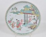 Medalhão de porcelana japonesa, decorado por figuras femininas  e vegetação, em rica policromia em relevo, borda floral. Marca impressa: Yamatoku (virtude da montanha) em caracteres 'katagana', esta marca ocorre principalmente por volta de 1910-20, e marca em  vermelho de quatro caracteres. Diâmetro 31 cm.