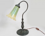 Graciosa luminária francesa, em bronze, cúpula no estilo Loetz, em pasta de vidro, trabalhos iridescentes, circa 1900. Altura 46 cm, base diâmetro 18 cm, medida da cúpula 18 x 13 cm.