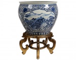 Imponente e antigo cachepot de porcelana chinesa azul e branca, com marca de 6 caracteres QIANLONG. Decorado com reservas de paisagens, Medindo 57 x 46 cm. acompanha antiga peanha de madeira com patina dourada. Medindo 57 x 36 cm. (D x A)