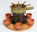 JEAN DOBRÉ PARA TROPIC ART e Cerâmica Landert - Conjunto para fondue composto de: Bandeja giratória em jacarandá e metal com 6 bowls de cerâmica, tabuleiro de madeira clara 42 cm. Fogareiro de metal decorado com vacas. 6 garfos de 40 cm. Linda panela de cerâmica verde esmaltada decorada com vaca (9 x 32 x 22 cm). B