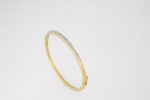 Elegante pulseira - bracelete em ouro 750 ml contrastado, parte central em ouro branco com oito pequenos brilhantes - aro - med. 5,9 cm de diâmetro - peso aproximado - 8,3 gr
