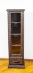 Pequena vitrine rústica em madeira entalhada, tampo retangular com uma porta central em vidro com puxador em madeira torneada, parte interna com quatro prateleiras, parte inferior com uma gaveta - med. 121x35,5x23 cm