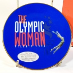 ESPORTE - OLIMPÍADAS. Prato em porcelana comemorativo / alusivo aos JOGOS OLIMPICOS DE ATLANTA 1996 - THE OLYMPIC WOMAN U.S.A., produto licenciado pela AVON PRODUCTS, INC NEW YORK com acabamento em ouro 22 K, acondicionado em estojo original, souvenir decorativo medindo 12,8 centímetros de diâmetro, sem uso.