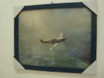 MILITARIA - Pôster de um Avião utilizado na segunda guerra mundial, devidamente emoldurado, com dedicatórias a serem traduzidas na parte inferior do pôster. A moldura mede aproximadamente 40 x 32 centímetros.