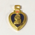 MILITARIA - Miniatura da MEDALHA AMERICANA PURPLE HEART. A Purple Heart ou Coração Púrpura é uma condecoração militar dos Estados Unidos, outorgada em nome do Presidente a todos os integrantes das Forças Armadas que sejam feridos ou mortos durante o serviço militar, desde 5 de abril de 1917. A condecoração original, com o nome de Distintivo do Mérito Militar, foi instituída por George Washington, então comandante do exército continental, em 7 de agosto de 1782. Ela foi concedida a apenas a três soldados a Guerra da Independência, caindo em desuso depois de seu término. Apesar de nunca ter sido abolida, a condecoração não foi mais proposta até depois da I Guerra Mundial, quando em 1927 o Congresso recebeu um pedido do comando do exército para revivê-la, mas negou a proposição. Em janeiro de 1931, o general Douglas MacArthur, então ocupante do cargo de chefe do estado-maior do exército, o mais alto posto da força, confidencialmente encomendou um novo desenho para a medalha, baseado no bicentenário de nascimento de George Washington. Uma especialista heráldica do exército foi encarregada dos estudos para a criação do novo desenho, baseada nas especificações de MacArthur.