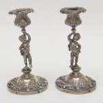 França Séc XIX - Par de castiçais em prata contrastada, bobeches removíveis, fuste em forma de puttis, altura 18 cm.