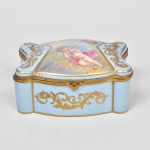 Sèvres - França Séc XIX, elegante caixa em porcelana, assinada Lix, tampa decorada com anjos, ricamente decorada a ouro, 6 x 13 x 10 cm. Em perfeito estado.