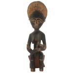 Antiga estatueta africana representando figura feminina com elaborada cabeleira, sentada em banquinho. África ocidental. Sinais do tempo. 40 x 12 cm. Peça pertencente ao acervo da Família de Paulo Fachini.