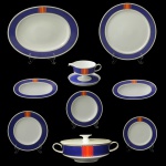 Rosenthal Studio-Line. Germany - Serviço para jantar em porcelana alemã. Fundo de superfície branca apresentando borda azul com detalhes em rouge de fer. No fundo marca da manufatura. Constando de 53 peças, sendo: 24 pratos rasos (25 cm), 12 pratos fundos (23 cm), 12 pratos p/ sobremesa (21 cm / 1 com bicado). 1 sopeira redonda (13 x 34 cm), 1 molheira com presentoir (8 x 17 x 12 cm / 18 cm), 1 travessa oval (38 x 29 cm), 1 prato para arroz (31 cm), 2 covilhetes (4 x 24 x 13 cm).